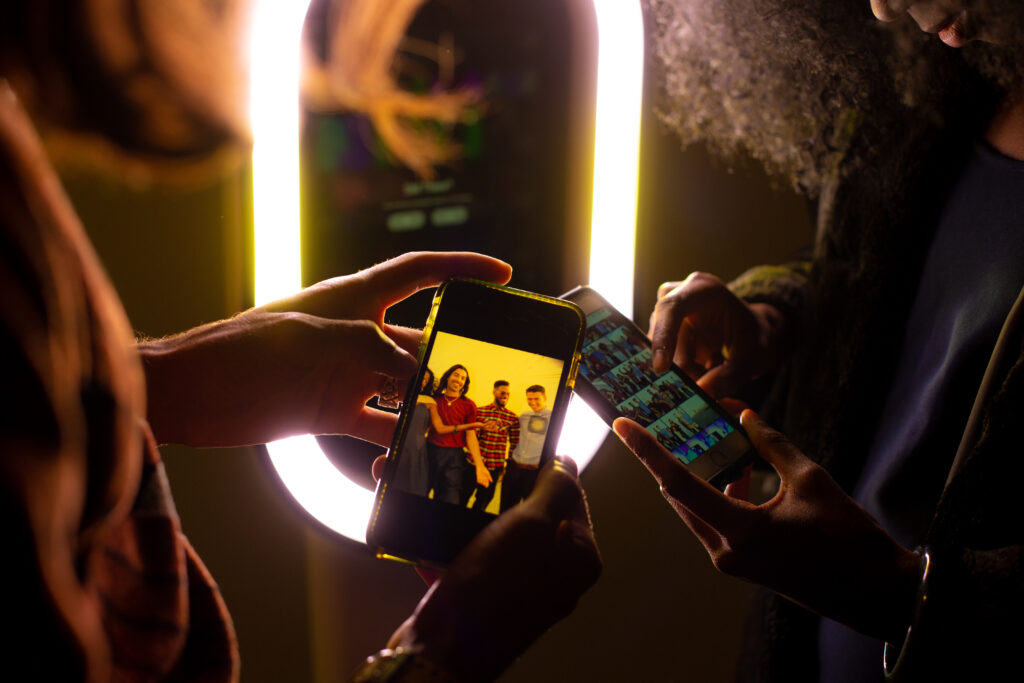 Guests enjoying instant photo booth memories, viewing their snapshots on their phones