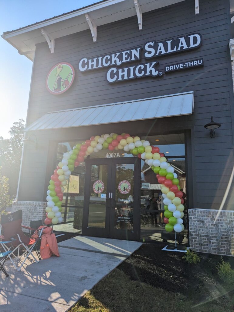 Storefront with a vibrant balloon arch welcoming guests
