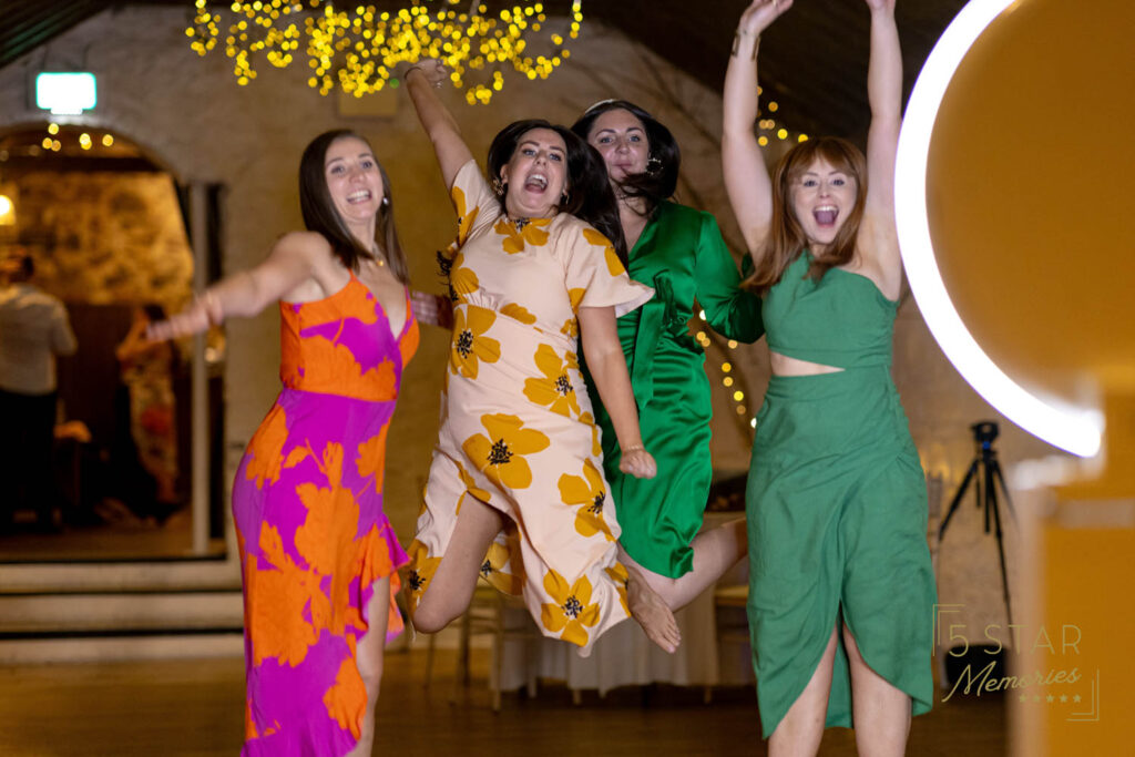 women joyfully jumping for a birthday party photo booth