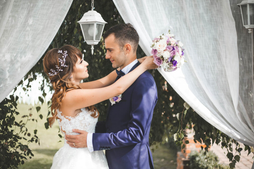 Bride and groom sharing an intimate moment under white drapery