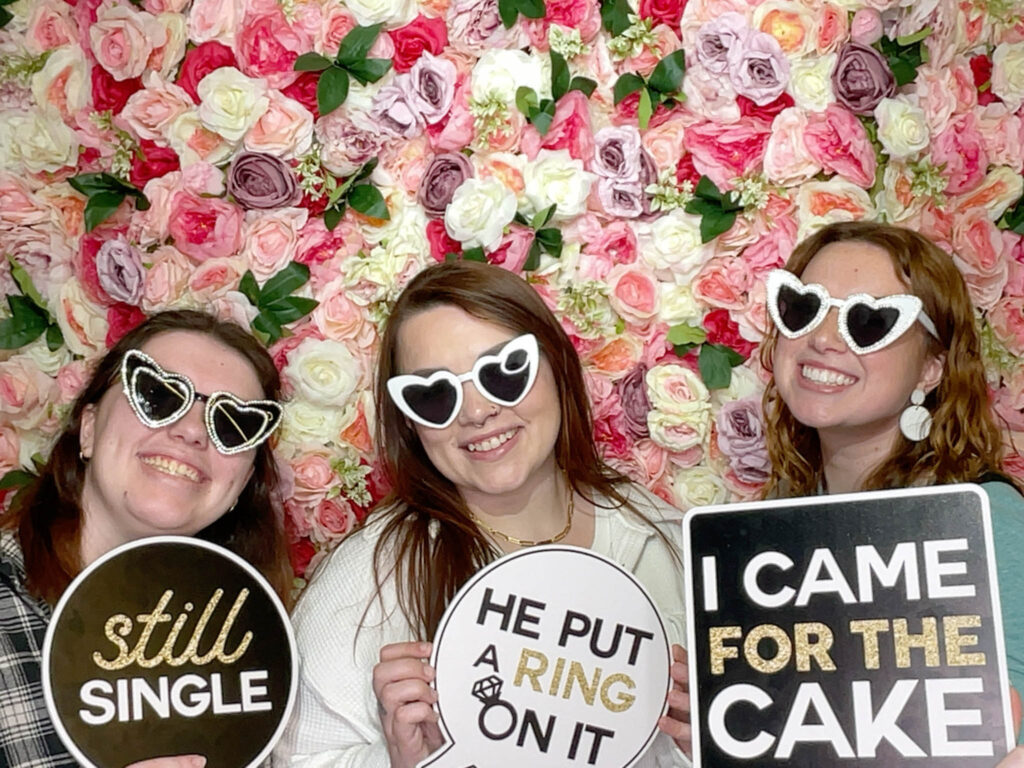 guests holding props on a photo booth