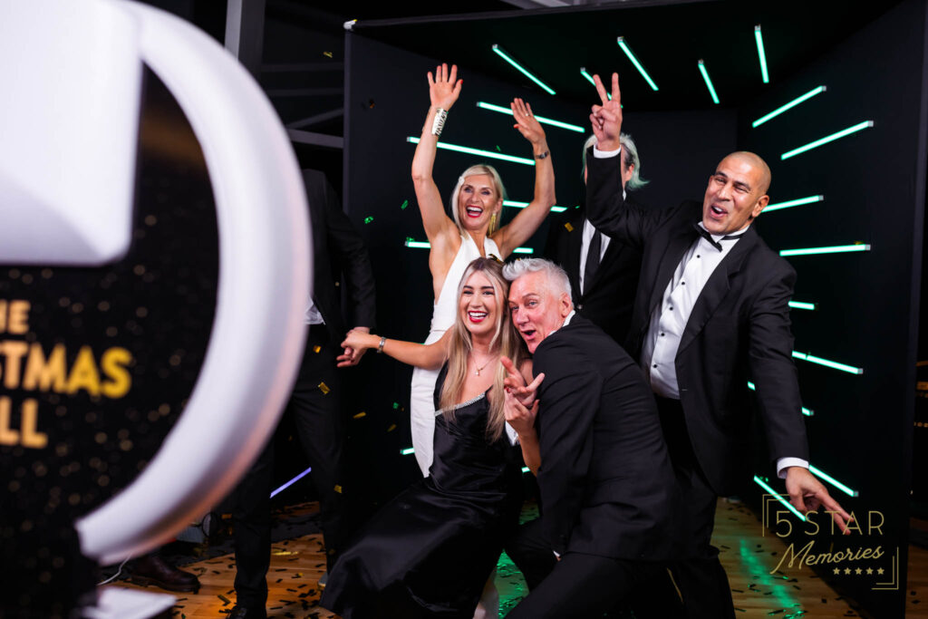 Ladies and gents at a gala, enjoying having their photos taken on the photo booth